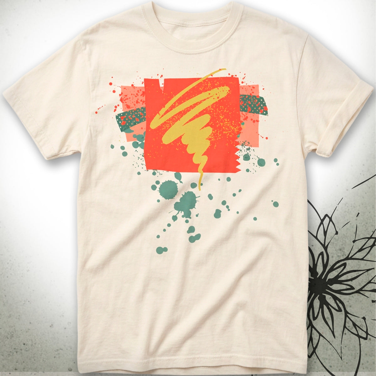A cream-colored short-sleeve t-shirt with a colorful abstract graphic print on the front, featuring a red square, yellow brushstroke, and green paint splatters, displayed against a textured gray background.