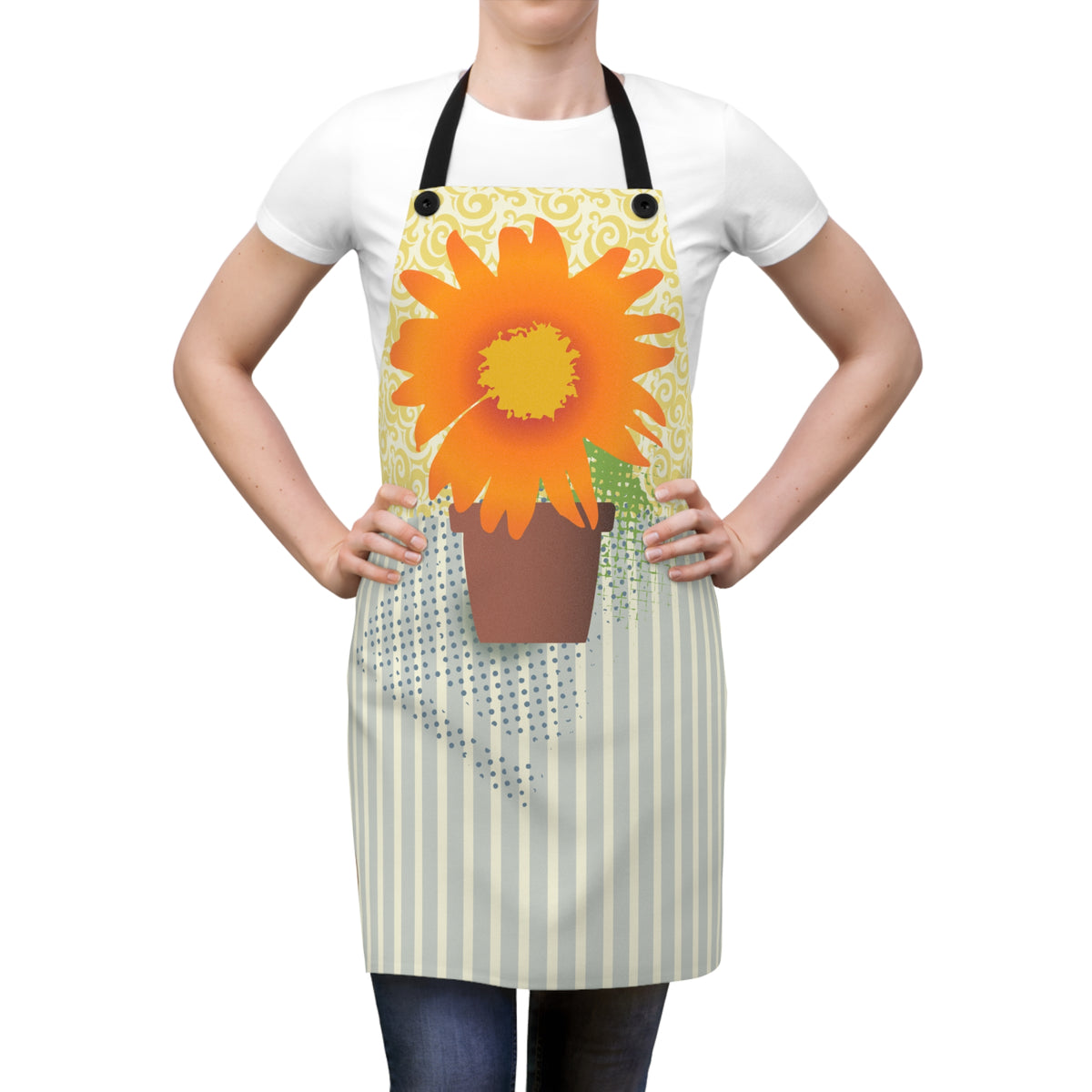 A person wearing a white apron with a large orange sunflower and brown pot graphic on the chest, over a white T-shirt and dark jeans, against a plain white background.