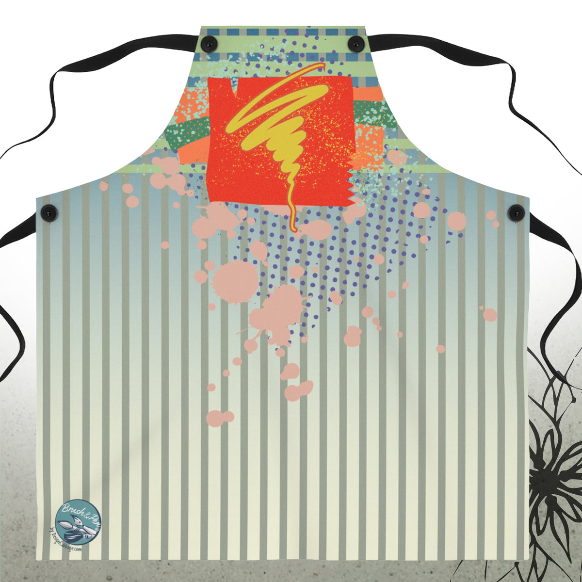 A bib-style apron with black neck and waist straps, featuring a colorful abstract print. The design includes vertical cream and light blue stripes, pink paint splatters, blue dots, a red square with a yellow swirl, and a small circular logo in the bottom left corner.