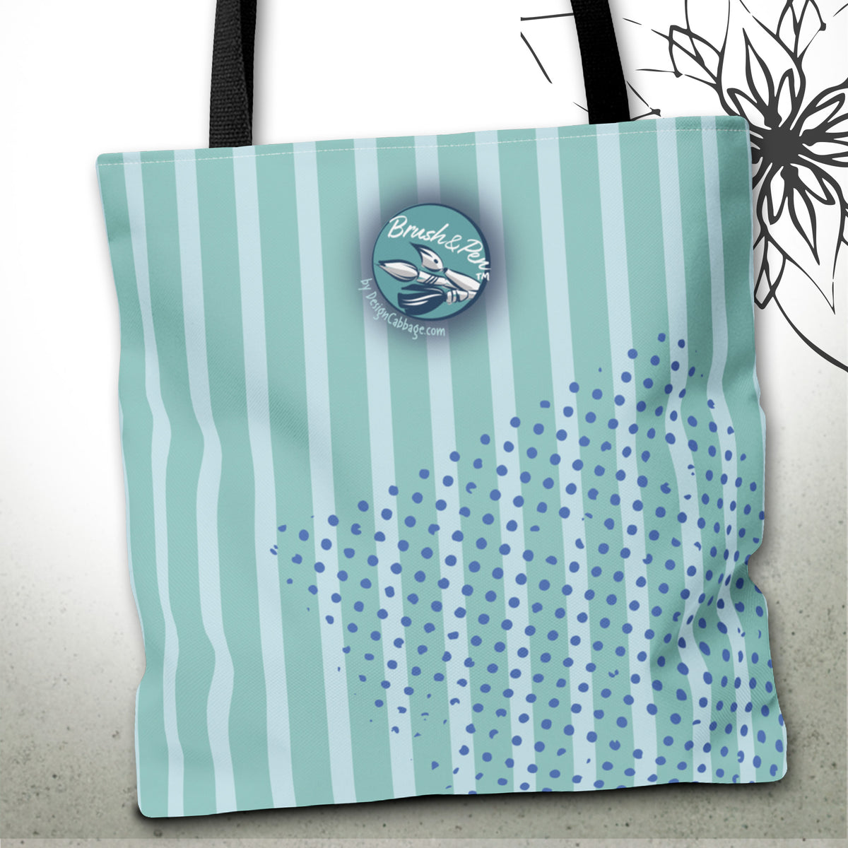 A tote bag with vertical mint green and white stripes, a blue polka dot splash design on the lower right, and a circular 'Brush&Pen' logo patch on the front. The bag has black shoulder straps and is shown against a light gray background with a decorative black floral graphic in the upper right.