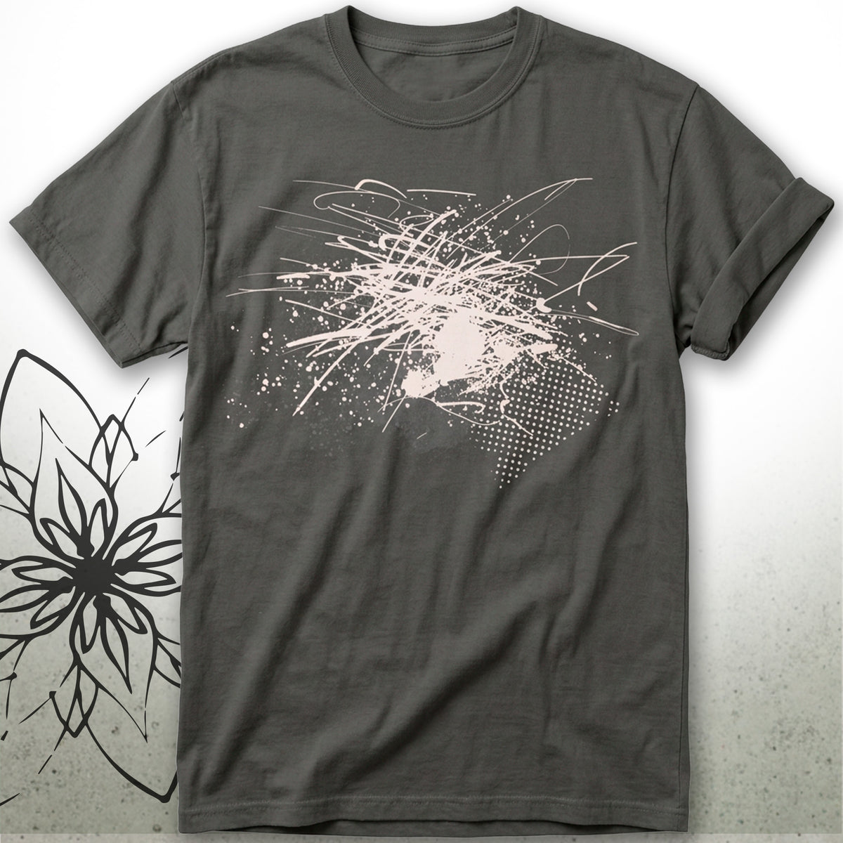 A dark charcoal gray t-shirt with a light beige abstract graffiti-style graphic on the front, displayed flat against a light gray background with a black floral line-art overlay on the bottom left.
