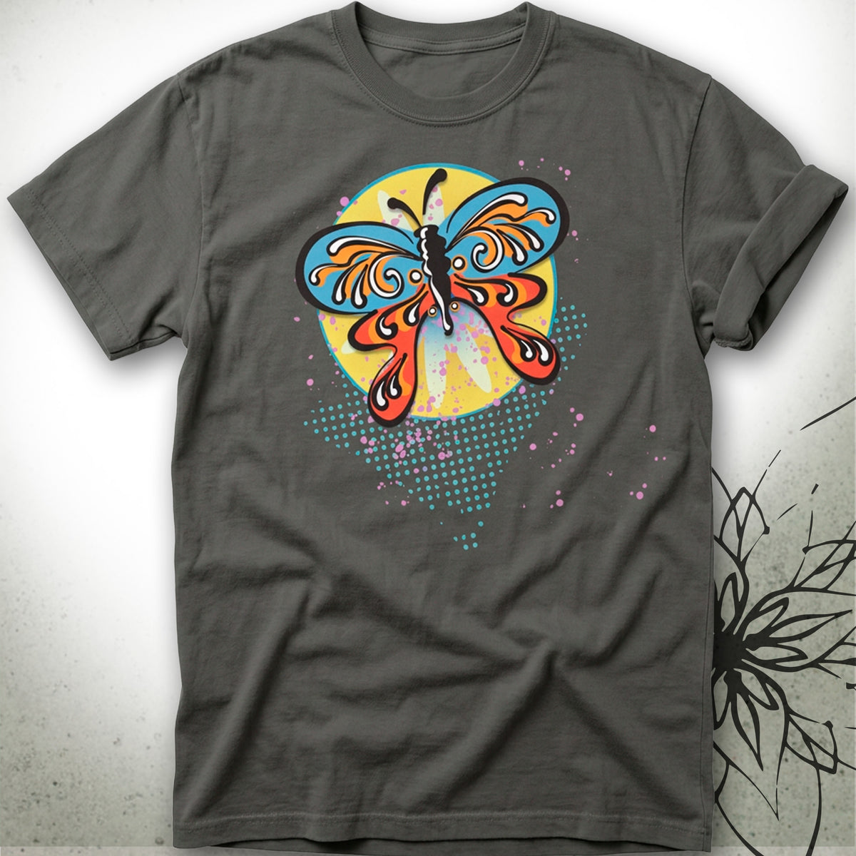 A dark gray crewneck t-shirt featuring a colorful graphic of a butterfly with blue, orange, and yellow wings, set against a textured light gray background.