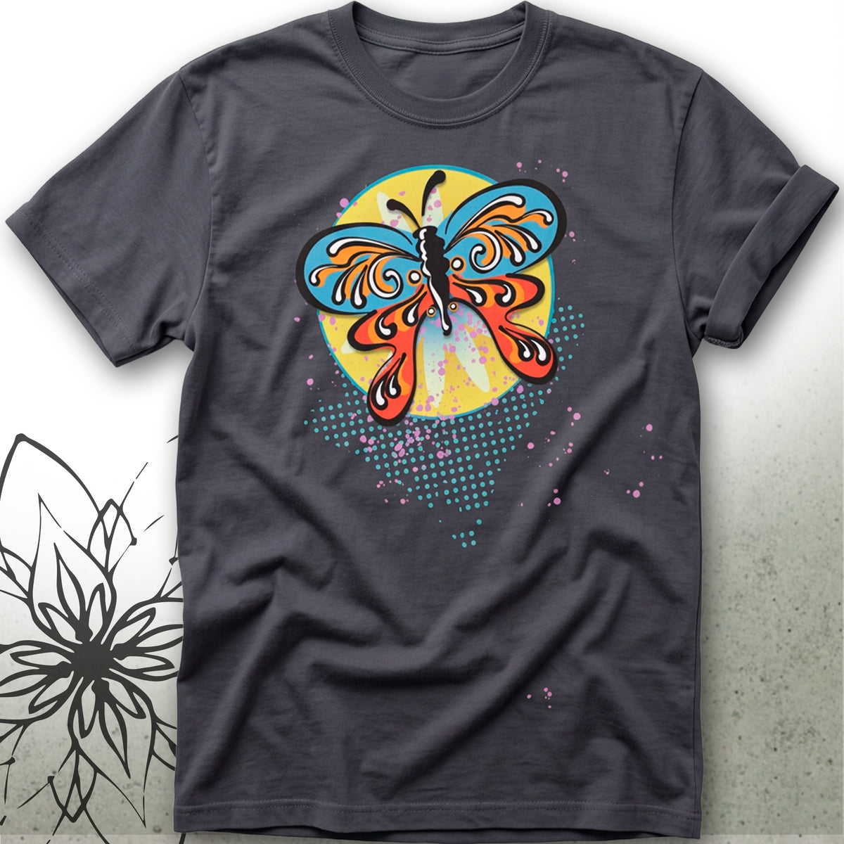 A dark gray crewneck t-shirt featuring a colorful butterfly graphic on the front. The butterfly has blue, orange, and red patterns over a yellow circular background, with teal halftone dots below.